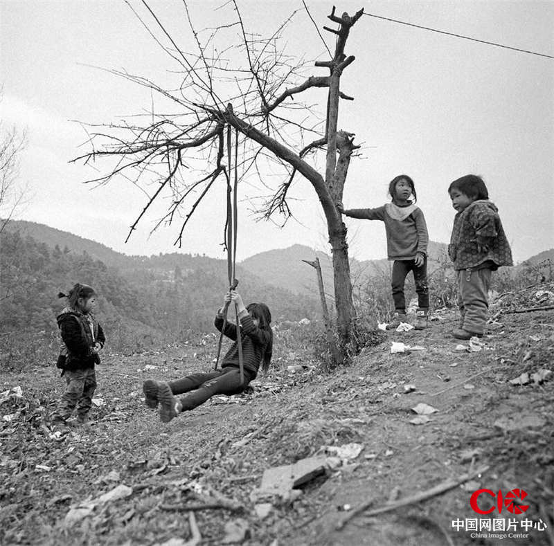 爸妈走了，留在村里的小孩子们在树下荡秋千玩耍。