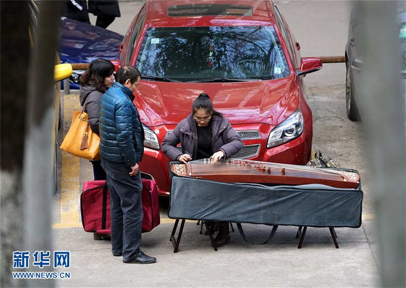  1月15日，一名考生在考场附近的停车场练习古筝。