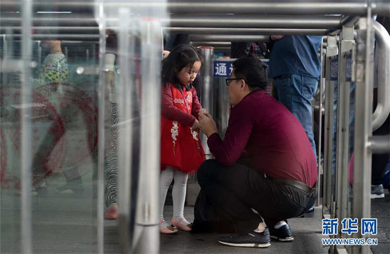2月2日，在深圳北站，一名父亲蹲在进站口与女儿告别。