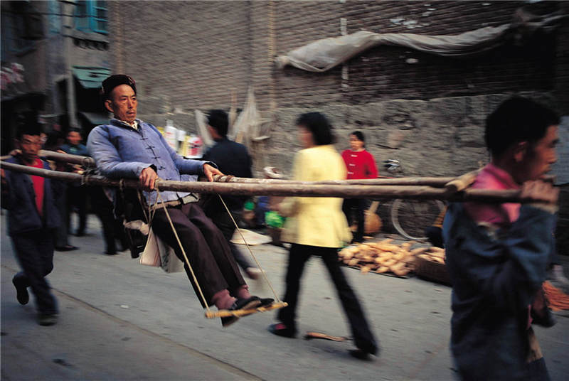 1991 湖北秭归 长江三峡，秭归老县城里坐滑竿的人 彩色