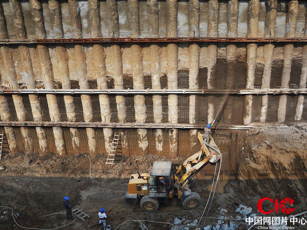新機場主航廈建築面積140萬平方米，前期基礎工程打樁9000多根。建築工人在實施地下樁梁水泥加固作業。