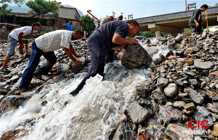 8月3日，磁县南王庄村，村支部书记王海军正带领大家在湍急的河水中抢修水毁的临时路。