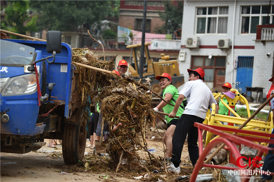 8月3日，磁县中岔口村，志愿者正在村民文化广场上清除淤泥。