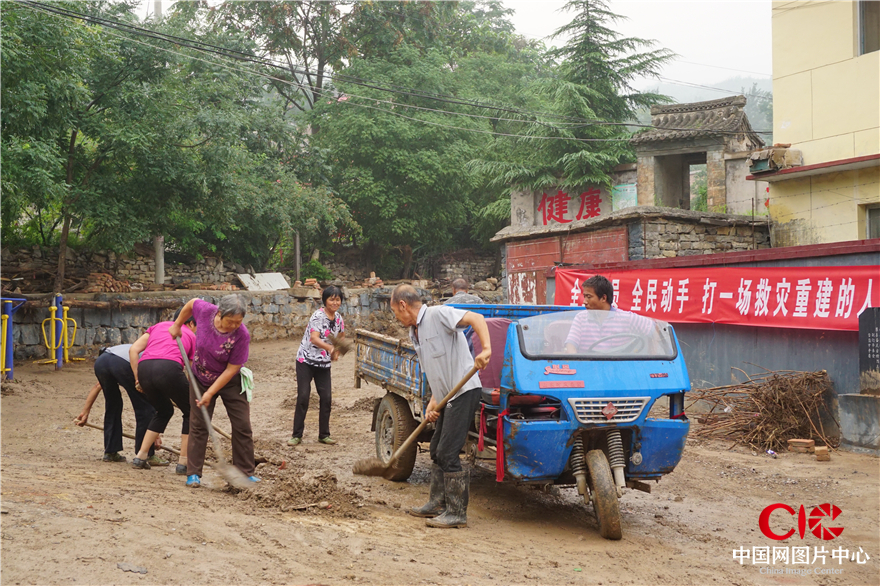 村民在清理村中的淤泥垃圾