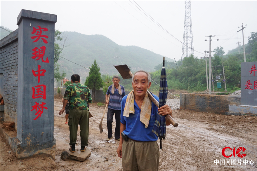 这位70多岁的老人也主动的去清理村里的淤泥