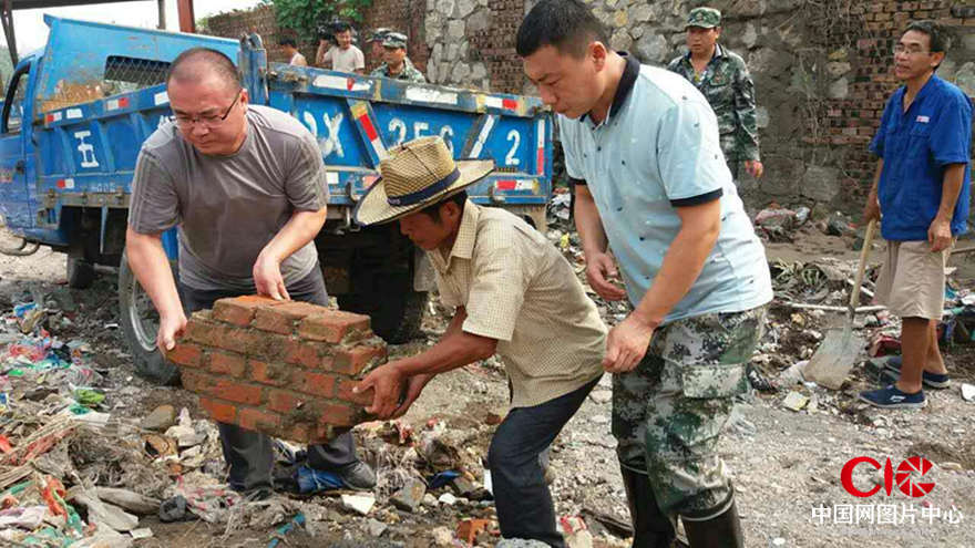 邯鄲市峰峰鎮黨委書記李波帶領全鎮黨員、幹部與群眾一起勞動，清理災後垃圾。