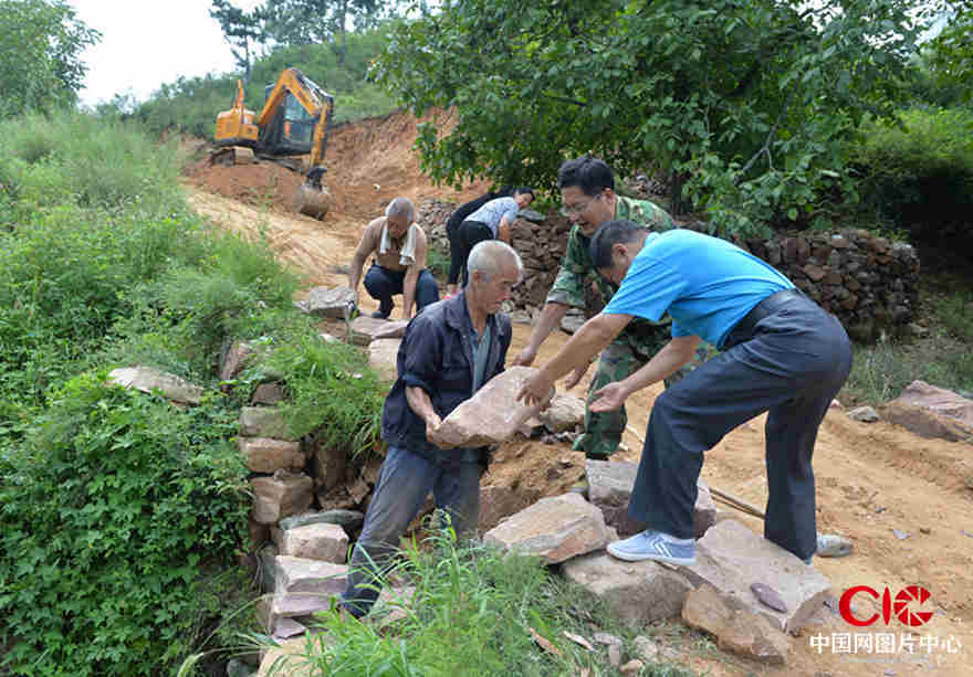 黨員抗洪救災突擊隊正在修整出村的道路 張震